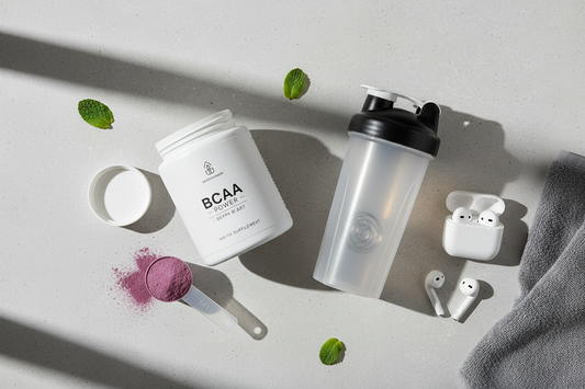 Clean lifestyle shot of BCAA powder beside a shaker and workout gear