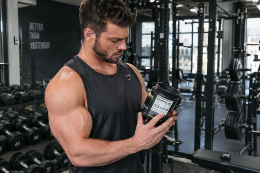 A lifter checking the caffeine amount on a pre-workout container