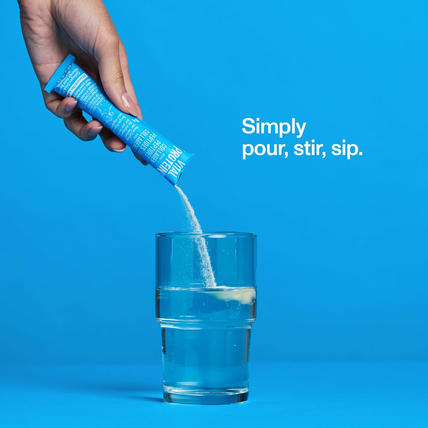Hand pouring a blue powder from a packet into a glass of water against a blue background with text 'Simply pour, stir, sip'.